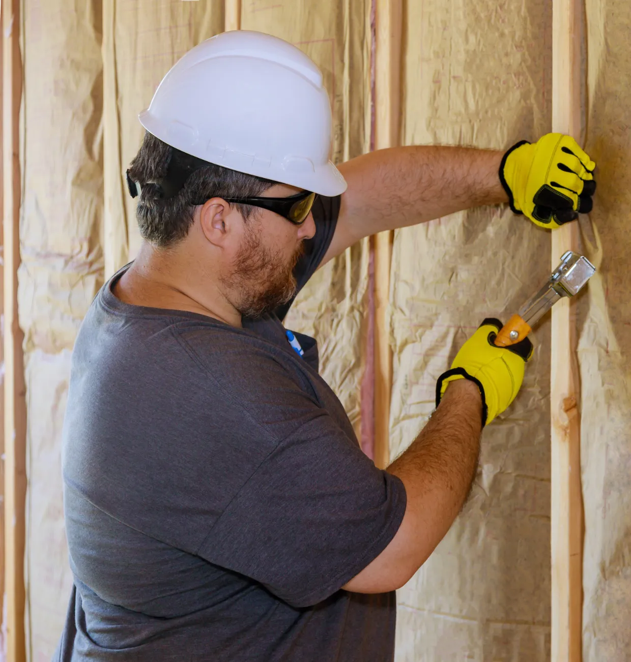 ADU construction worker installing wall insulation during accessory dwelling unit build in Los Angeles