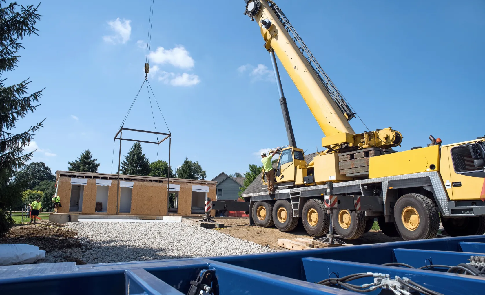 Crane installing modular prefabricated ADU structure at Los Angeles residential construction site
